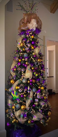 a christmas tree decorated with purple and gold ornaments