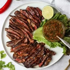 steak, lettuce and sauce on a white plate