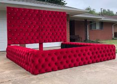 a large red couch sitting in front of a house