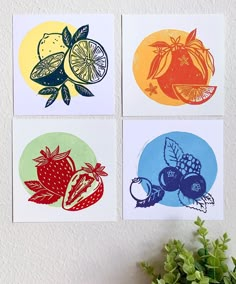 four cards with fruit and vegetables on them are displayed next to a potted plant