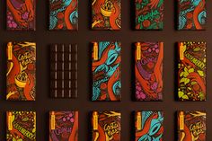 chocolate bars with colorful designs on them are lined up against a brown wall and placed next to each other