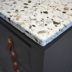 a white and black dresser with brown handles