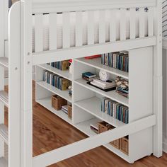 a white bunk bed with bookshelves and drawers on the bottom shelf in front of it