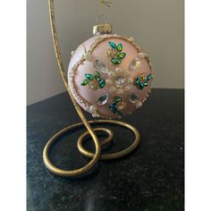 a pink ornament with green and blue butterflies hanging from it's side