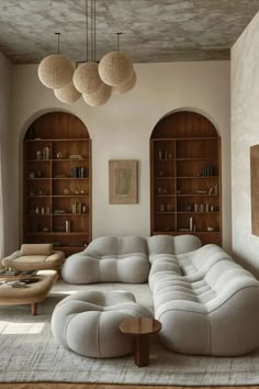 a living room filled with furniture and bookshelves next to a wall mounted book shelf