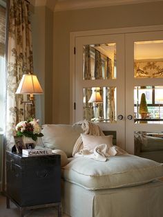 an image of a living room with furniture and decor on the walls, in front of a mirror