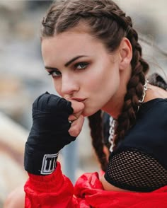 a young woman with braids and gloves on her head is posing for the camera