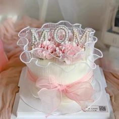 a mother's day cake decorated with pink flowers and the word mom on top