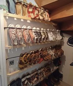 there are many pairs of shoes hanging on the wall in this shoe rack that is filled with them