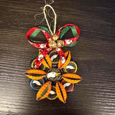 an ornament hanging from a wooden table with ribbon and decorations on it's side