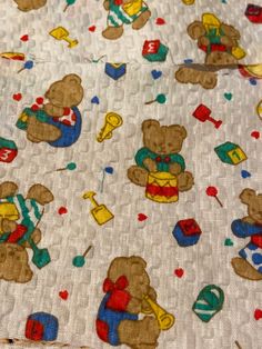 a teddy bear print fabric with hearts and other things on it, as well as the background