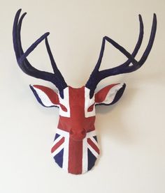 a red white and blue deer head with the british flag on it's antlers