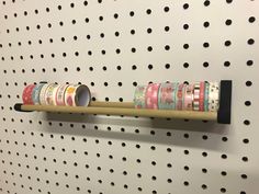 several rolls of tape are hanging on a pegboard