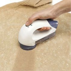 a person is using an iron on a piece of cloth to clean the fabric with their hand