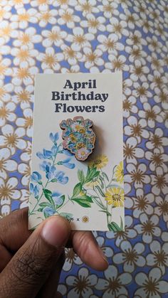 a person holding up a card with a flower on it that says, april birthday flowers