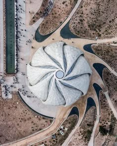 an aerial view of a large building in the middle of a desert with lots of people walking around it