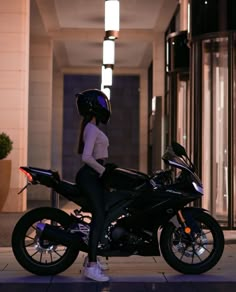 a woman sitting on top of a black motorcycle