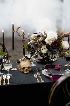 the table is set with silverware, candles and flowers in vases on it