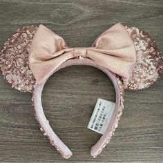 a pink minnie mouse ears headband with sequins and a bow on top