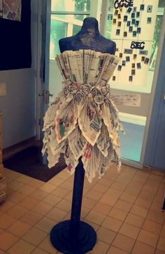 a mannequin made out of newspapers sitting on top of a table