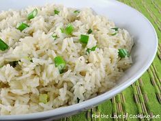 a white bowl filled with rice and green onions