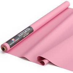 a roll of pink colored paper sitting on top of a white surface