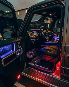 the interior of a vehicle with its door open and lights on at night time,