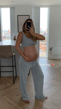 a pregnant woman taking a selfie with her phone