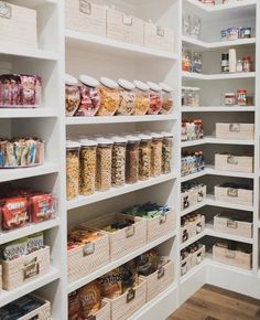 an organized pantry with white shelving and lots of food in baskets on the shelves