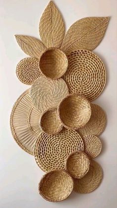 a wall hanging made out of woven material with leaves and circles on the bottom half