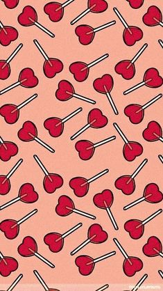 a pink background with lollipops and sticks in the shape of hearts on them