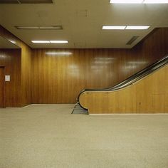 an empty room with a long escalator in the middle and no one on it