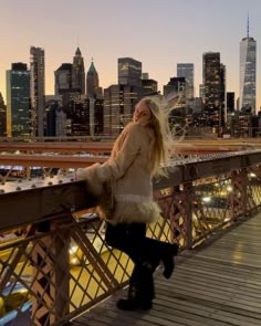 a woman standing on top of a bridge next to tall buildings