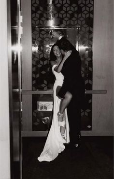 a man and woman are hugging in an elevator