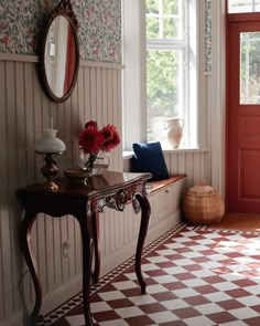 a room with a checkered floor and wall paper on the walls is decorated with red flowers