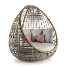 a wicker chair with cushions and pillows on it's back end, sitting in front of a white background