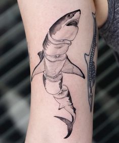 a woman's arm with a shark tattoo on it