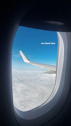 an airplane window looking out on clouds and blue sky with the words cloud nine above it