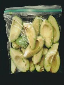 an avocado in a plastic bag on a black background