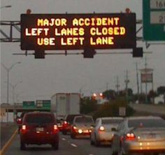 a sign that reads fail on the side of a road with cars driving underneath it