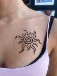 a woman with a sun tattoo on her chest