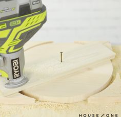 a close up of a sanding tool on top of a piece of plywood