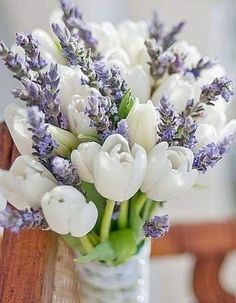 a vase filled with white and purple flowers