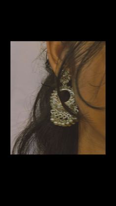 the back of a woman's head with her hair pulled up and wearing an animal print earring