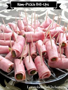 ham - pickle roll - ups on a plate with toothpicks in them