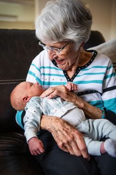 an older woman holding a baby in her lap