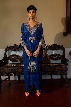 Editor's Note Featuring a deep blue self-woven kaftan with hand embroidery on yoke and cuffs. This elegant piece comes embellished with careful antique embroidery detailing. Color: Blue Fabric: Russian jacquard Component: Kaftan Fit: Relaxed Occasion: Resort and evening wear Care: Dry Clean Only About the Designer Paulmi & Harsh is a luxury prêt label inspired by beautiful botanicals. Paulmi & Harsh design strong, feminine silhouettes with prints and delicate detailing, fusing 1950’s fashion wit Luxury Royal Blue Kurta For Festive Occasions, Luxury Traditional Royal Blue Kurta, Luxury Blue Mulmul Traditional Wear, Luxury Semi-stitched Festive Kaftan, Luxury Royal Blue Festive Kurta, Luxury Blue Bollywood Kaftan, Luxury Royal Blue Sets With Resham Embroidery, Luxury Blue Traditional Wear For Ceremonial Occasion, Luxury Blue Ceremonial Kaftan