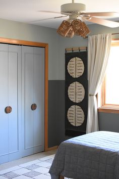 a bed room with a neatly made bed and a ceiling fan