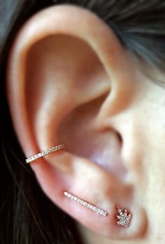 a close up of a person's ear with two piercings