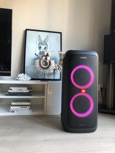 a speaker sitting on top of a table next to a tv